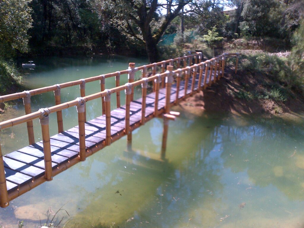 Puente artesanal de caña de bambú guadua con uniones de cuerda natural en jardín exterior