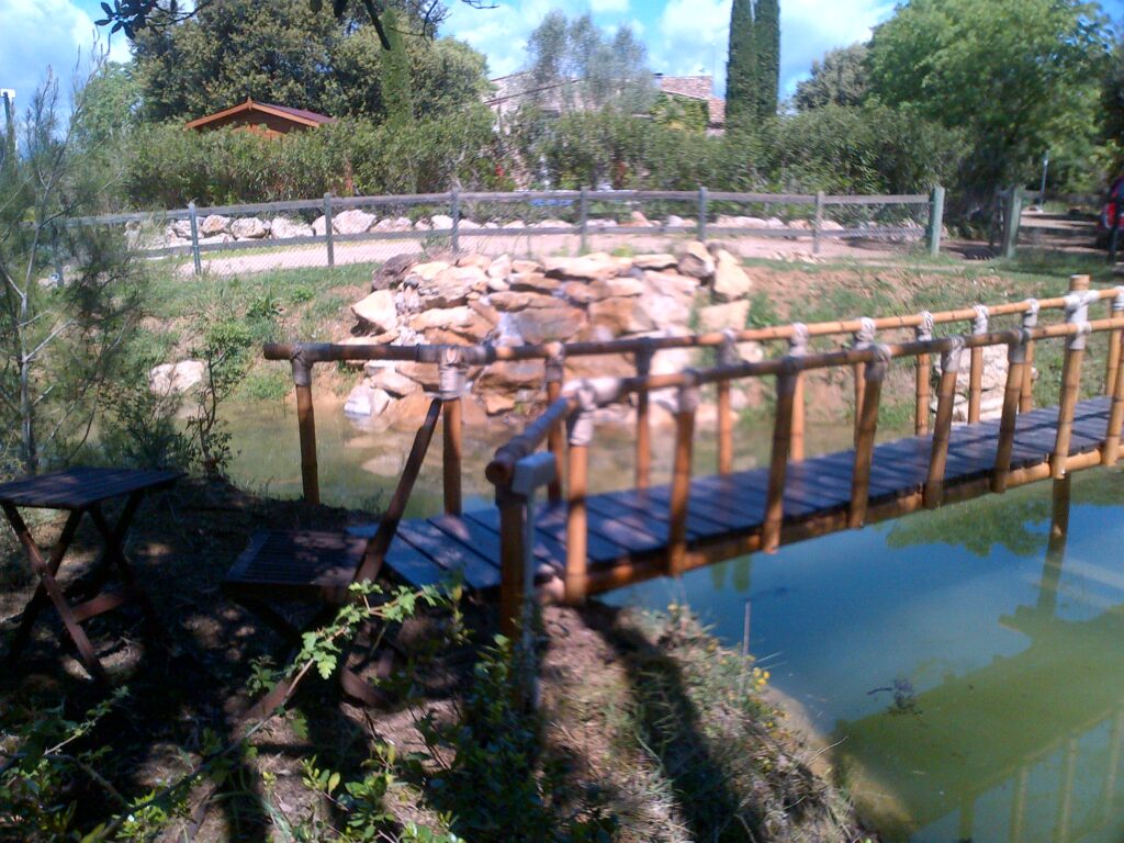 Puente artesanal de caña de bambú guadua con uniones de cuerda natural en jardín exterior