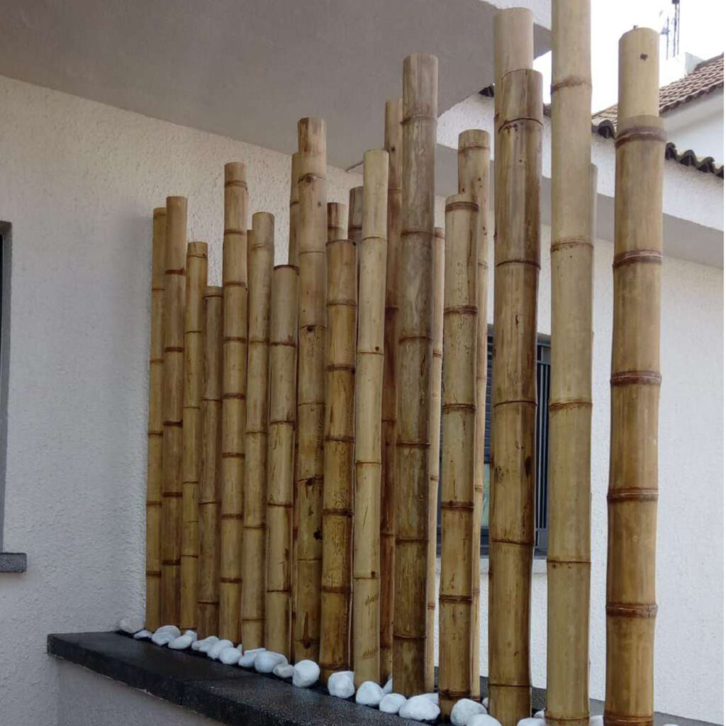 Biombo decorativo de cañas de bambú en jardinera para separar la entrada de una casa moderna